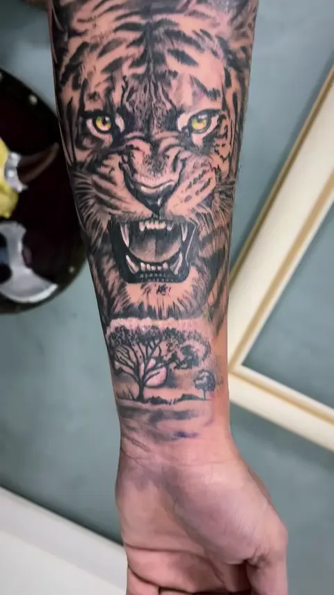 Tigre rugindo em realismo preto e cinza no antebraço