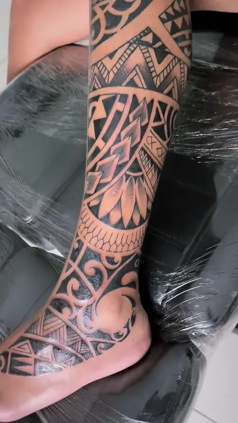 Grafismo maori em preto cobrindo a perna até o pé